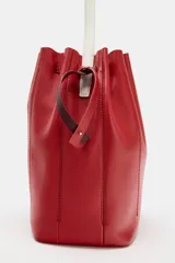 Bolso de hombro formato maxi de piel, en combinación de colores rojo y bordó. Cuenta con detalle de pespuntes, bolsillo interior con cremallera extraíble y cierre mediante fruncido con asas finas de hombro.