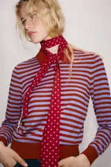 Jersey de punto con diseño a rayas horizontales en color rojo y lila, cuello solapa tipo polo con cierre frontal de botones y manga larga.