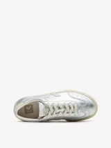 Championes Veja modelo Volley, de diseño urbano en color plateado metalizado. Presentan el logo lateral en tono crema, suela de caucho natural y detalles de costuras decorativas en la puntera.
