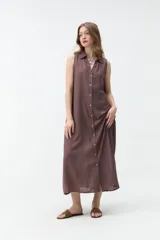 Vestido largo sin mangas de color celeste, con cuello camisero, cierre frontal con botones y bolsillos laterales.