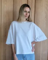 Remerón blanco de algodón, de corte holgado, cuello redondo y mangas cortas amplias.