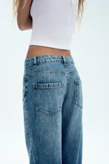 Jeans wide leg de tiro alto, color azul con efecto deslavado, cintura con trabillas, diseño de cinco bolsillos y cierre frontal con cremallera y botón metálico.