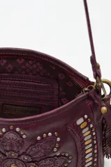 Cartera de cuero vacuno color negro con diseño de mandala floral bordado y tachas metálicas decorativas. Cuenta con correa ajustable, cierre superior y detalle de flecos laterales.