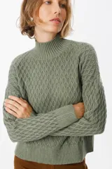Sweater de tejido de punto con textura de panal, cuello alto y puños acanalados. Presenta un diseño de calce holgado y mangas largas.