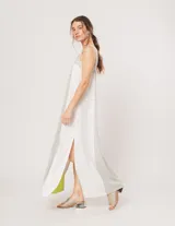 Vestido largo de lino color blanco, gris y amarillo, con breteles anchos, escote recto, elástico en la espalda y tajos laterales.