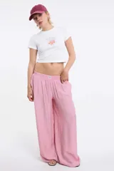 Pantalón de corte amplio y pierna recta, confeccionado en tela texturizada color rosa. Presenta cintura elastizada con cordón ajustable y bolsillos laterales.