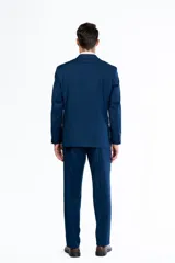Traje de dos piezas color azul intenso, compuesto por un saco de corte clásico con solapas y un pantalón de vestir de corte recto. Confeccionado en tejido de poliviscosa.