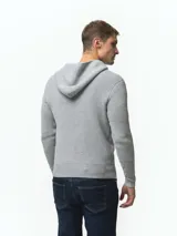 Campera tejida con capucha, confeccionada en poliéster, con cierre frontal completo y diseño de punto acanalado.