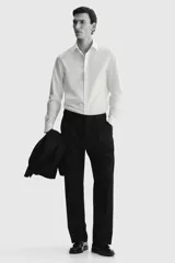 Camisa de corte entallado con cuello inglés, tapeta clásica y canesú en la espalda. Presenta mangas largas con puños ajustables mediante botones y bajo levemente redondeado. Confeccionada en tela con tratamiento de fácil planchado.