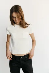 Jeans de tiro bajo y corte recto holgado, con efecto encerado en color negro, cinco bolsillos y trabillas para cinturón. Cierre frontal con cremallera y botón metálico.