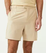 Bermuda color beige, corte slim, con elástico en la cintura, cierre con cremallera y bolsillos laterales.