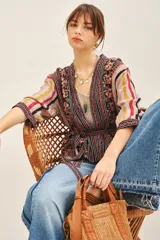 Kimono corto con mangas 3/4, confeccionado en viscosa estampada con diseño floral y rayas verticales. Presenta un cierre frontal cruzado con lazo ajustable en la cintura y forrería interior.