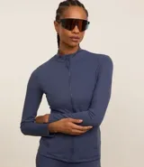 Campera deportiva azul con cierre frontal, cuello alto y bolsillos laterales.