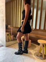 Botas de cuero negro de caña alta con múltiples correas con hebillas plateadas y suela de goma.