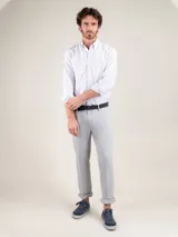 Camisa de hombre Oxford a rayas celestes y blancas, confeccionada en 93% algodón y 7% algodón reciclado. Corte regular fit, cuello button-down, cierre con botones, manga larga con puño simple y logo bordado en el pecho.