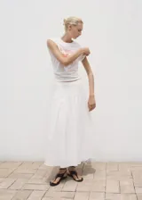 Camiseta blanca de algodón con cuello redondo, manga corta y diseño estampado en color rojo en la parte frontal.
