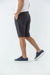 Bermuda tipo chino de gabardina, con diseño de cinco bolsillos, cierre de cremallera y botón, y detalle de botamanga.