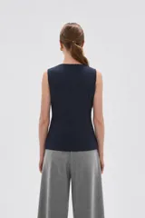 Chaleco sin mangas de corte sastrero, color marrón con diseño de rayas verticales finas. Presenta cuello redondo, cierre frontal con botones y dos bolsillos laterales simulados.