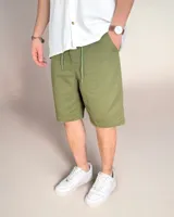 Bermuda color verde oliva de lino, corte holgado y largo hasta la rodilla.