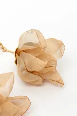 Aros colgantes dorados con diseño de flor de tela marrón translúcida y cierre de presión.
