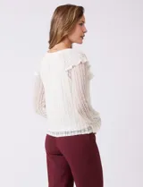 Blusa de encaje color beige, marca Cupio, con cuello a la base y escote en V con lazo de ajuste. Presenta una sobrecapa de encaje con aplique de puntilla y mangas largas de encaje floral translúcido, terminadas en puños elásticos con volado. Incluye forro interno a tono.