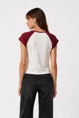 Remera al cuerpo con diseño raglán, color blanco en el torso y azul marino en las mangas cortas y el cuello. Cuenta con un estampado frontal de temática de tenis con las inscripciones "Portofino Tennis" y "Summer Italia".