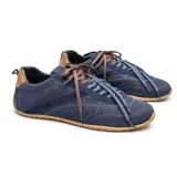 Championes de gamuza en color azul marino, con suela de goma color caramelo y detalles en cuero marrón en el talón. Presentan cordones combinados en marrón y azul con patrón de puntos.