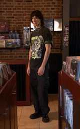 Remera de algodón premium con calce oversize, cuello redondo y mangas cortas. Presenta un estampado gráfico frontal con temática de Daft Punk en tonos verdes y negros.