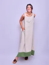 Vestido largo sin mangas color beige con ruedo verde, de corte amplio y estilo casual.