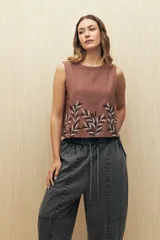 Pantalón de algodón color gris oscuro, estilo baggy o ancho, con cintura elástica y cordón ajustable. Presenta costuras marcadas que definen paneles en la pierna y puños ajustados en el tobillo.
