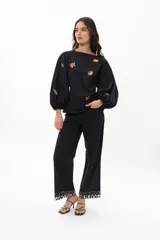 Blusa blanca de algodón con mangas largas voluminosas y escote a la base. Presenta bordados artesanales coloridos con motivos marinos distribuidos en el frente y en las mangas.