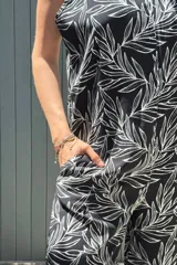 Mono largo confeccionado en fibrana con estampado de hojas blancas sobre fondo negro. Presenta breteles finos, escote en V y un calce holgado y fluido ideal para el verano.