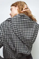 Camisa oversize de algodón con estampado de cuadros, cuello solapa, manga larga con puños y cierre frontal con botones. Presenta un detalle de pañuelo integrado en el mismo tejido que se anuda en la parte frontal.