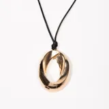 Colgante dorado con dije ovalado y tiento negro regulable.