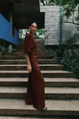 Pantalón palazzo de tiro medio en color marrón, confeccionado en tejido con textura. Cuenta con cintura elástica ajustable mediante cordones y diseño de pierna ancha.