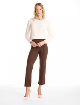 Pantalón cigarette de tiro alto color marrón, confeccionado en tejido elastizado. Presenta un diseño de pretina ancha y plana sin cierres, con costuras verticales pronunciadas a lo largo de cada pierna y corte recto al tobillo.