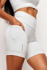Short tipo biker de tiro alto, diseñado para running y entrenamiento. Confeccionado en tejido técnico de alta performance con bolsillos laterales funcionales y bolsillo interno en la cintura. Presenta detalles reflectivos y costuras estratégicas para mayor libertad de movimiento.