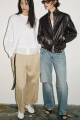 Camiseta oversize de cuello redondo y manga larga con puños abotonados. Confeccionada en algodón, presenta un diseño con combinación de tejidos a tono y bajo asimétrico.