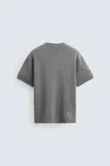 Camiseta de manga corta color amarillo pálido, con cuello redondo acanalado y corte relajado.