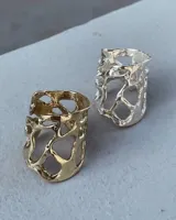 Anillo ancho de diseño orgánico y calado, con apariencia de red o magma solidificado.
