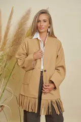 Chaqueta de paño color camel con terminación de flecos en el bajo, dos bolsillos delanteros y un botón. Es una prenda forrada, suave y de estilo clásico/moderno.