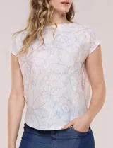 Buzo tejido de punto liviano y silueta holgada, con cuello bote cerrado, mangas cortas estilo japonesa, espalda de caída recta y ruedo curvo a la cadera. Presenta diseño estampado floral en tonos pasteles.