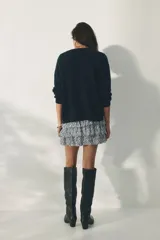Short pollera mini de viscosa con volados, sección fruncida en la cintura y estampado de patrón ornamental en tonos azules y blancos.