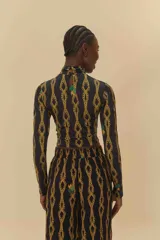 Top negro con estampado de cadenas doradas, cuello alto y mangas largas.