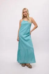 Vestido largo color celeste, de tirantes finos y espalda descubierta. Presenta volados en el ruedo y escote fruncido.