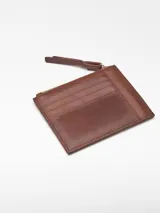 Monedero mediano de piel bovina de curtición vegetal, color rojo, con textura craquelada. Posee un compartimento principal con cierre de cremallera y un tarjetero en la parte trasera.