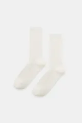 Calcetines de caña media color blanco hueso, con textura acanalada (canalé) en todo el cuerpo.