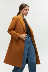 Tapado de paño azul con diseño de doble botonadura, solapas amplias y corte recto. Cuenta con bolsillos laterales discretos y forro interior.
