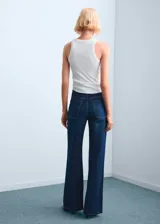 Jeans de denim azul oscuro con diseño de perneras anchas y tiro medio, de corte recto y clásico.