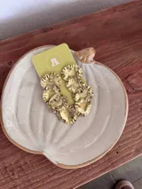 Caravanas de bronce dorado con diseño articulado de múltiples discos circulares ondulados.